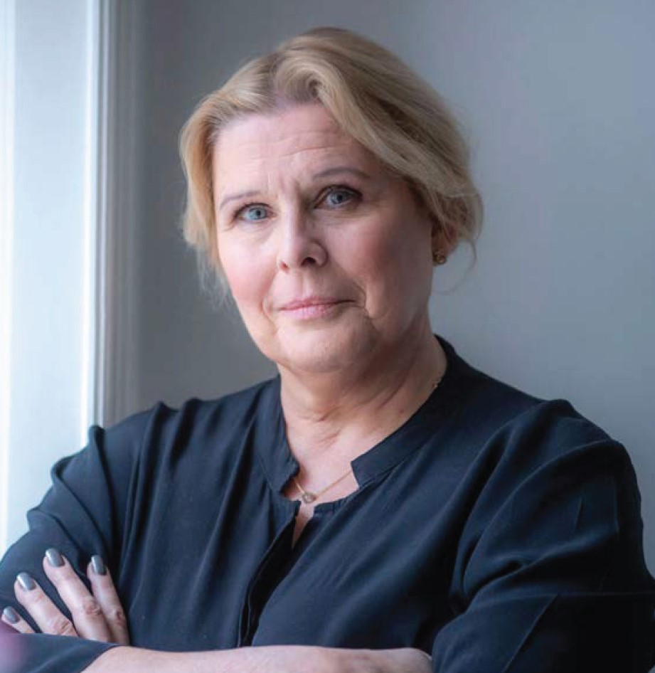 Porträtt på Ruth Kvarnström-Jones som är klädd i svart blus och har korsade armar