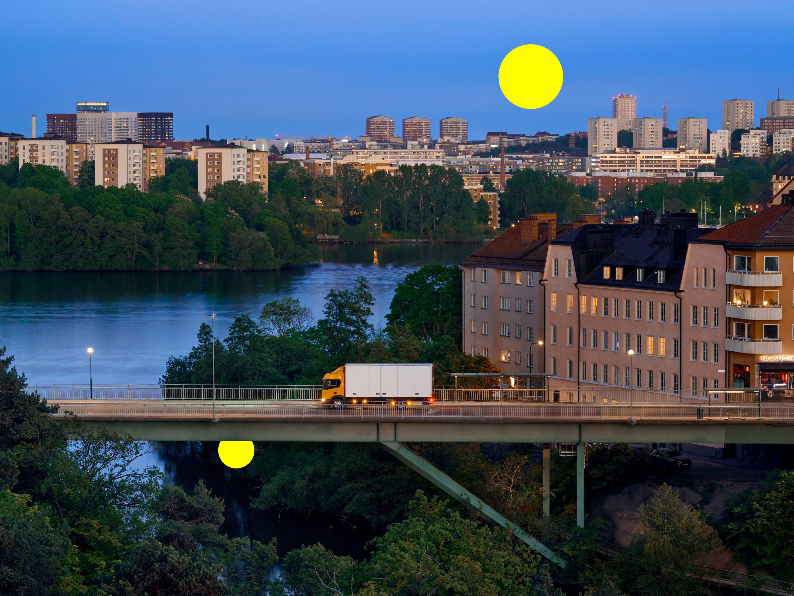 Lastbil kör över bro i Stockholm vid kvällstid, symboliserar transporter och handel mellan Sveriges regioner